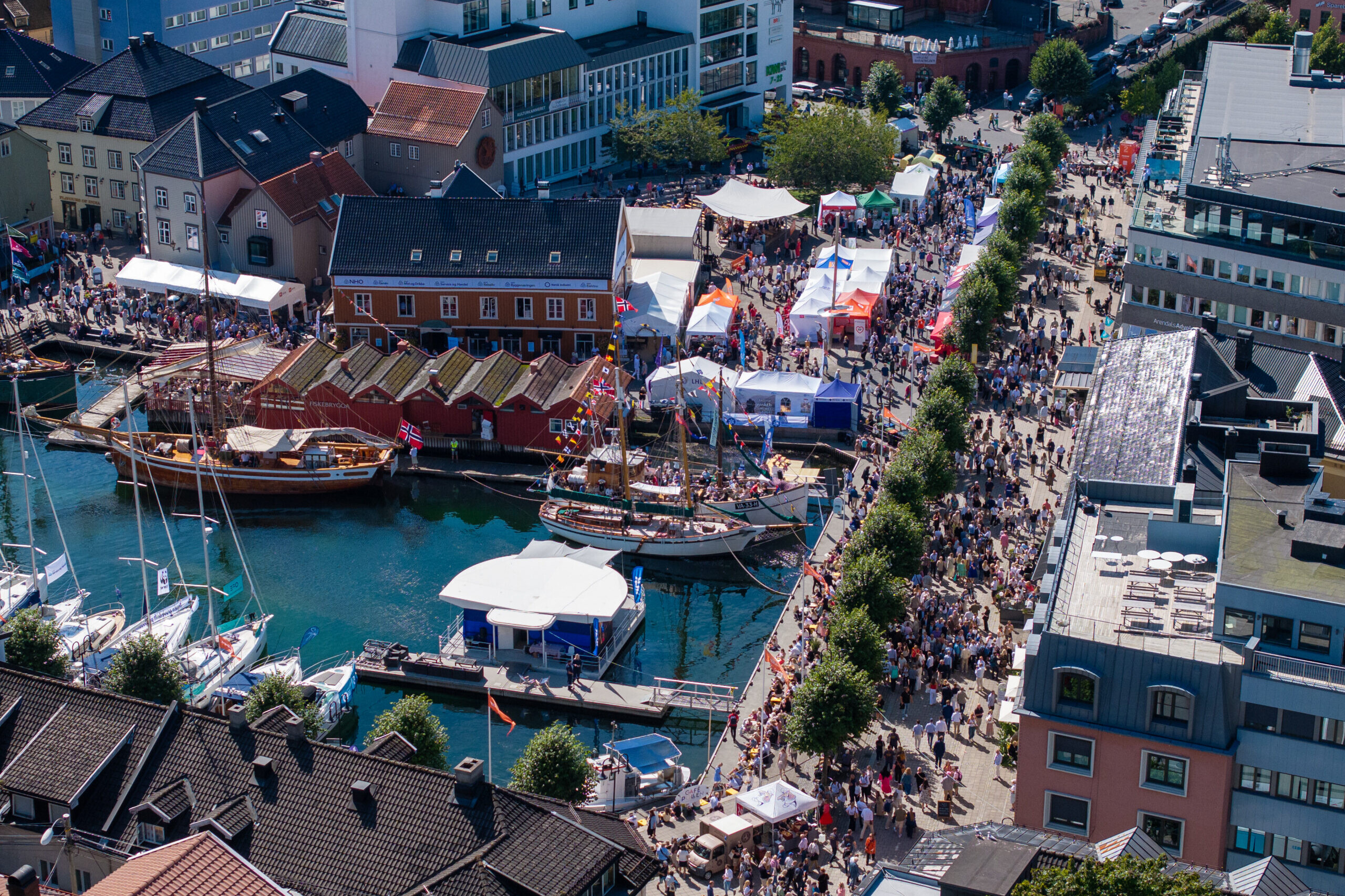 Dronebilde over et folkefullt Arendal Sentrum.